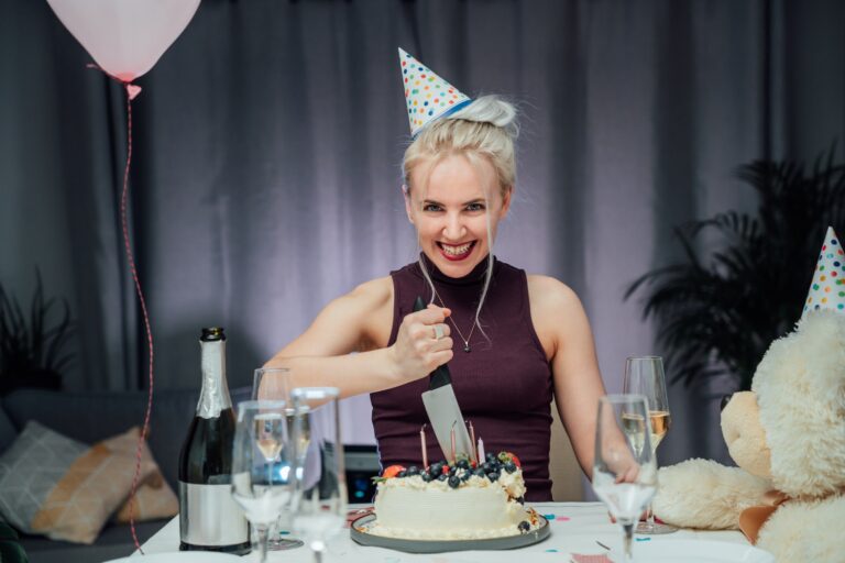 Portrait of Attractive crazy laughing birthday woman with bread-knife planning to cut birthday cake
